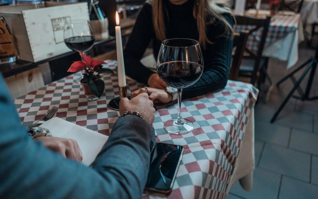 Couple holding hands at a candlelit restaurant table