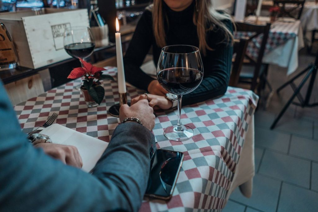 Couple holding hands at a candlelit restaurant table