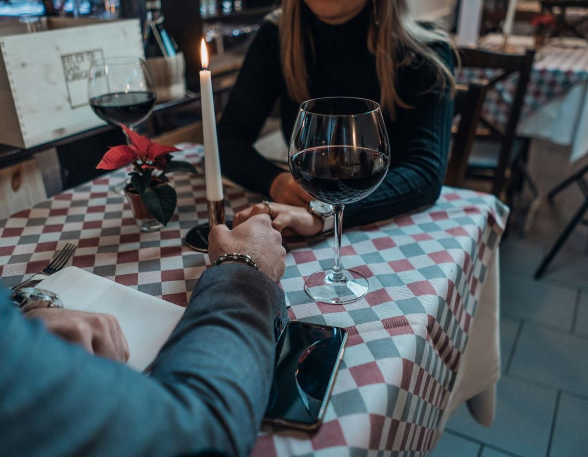 Couple holding hands at a candlelit restaurant table