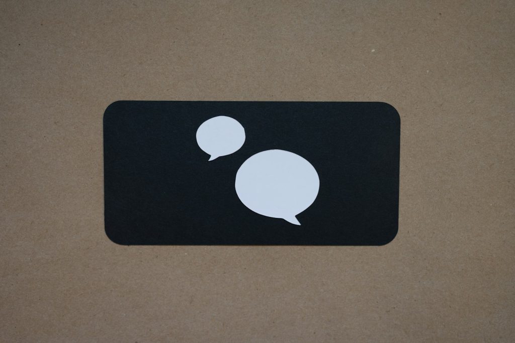 A white speech bubble icon on a black square, symbolising a chatbot conversation