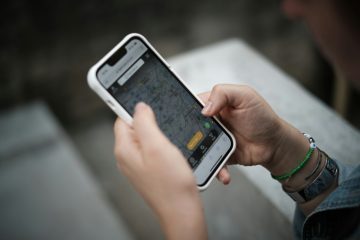 Рука держит смартфон на тёмном фоне