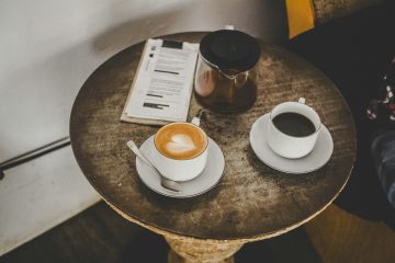 Two cups of coffee on saucers on a café table, set for a first date