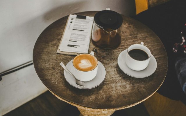 Two cups of coffee on saucers on a café table, set for a first date