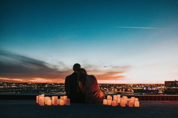 Couple on a rooftop at dusk surrounded by candles
