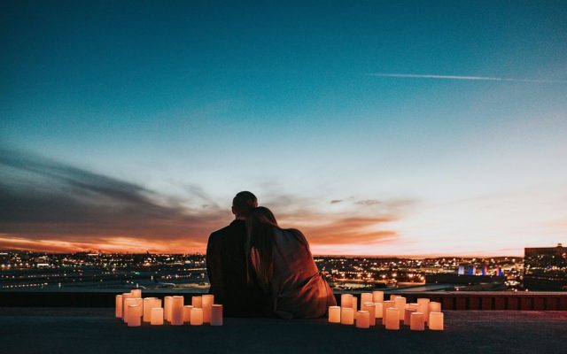 Couple on a rooftop at dusk surrounded by candles