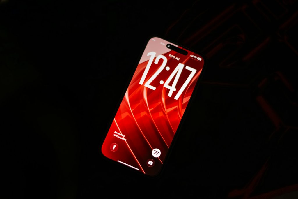 A smartphone with a red screen showing the time, suggesting a subscription renewal reminder