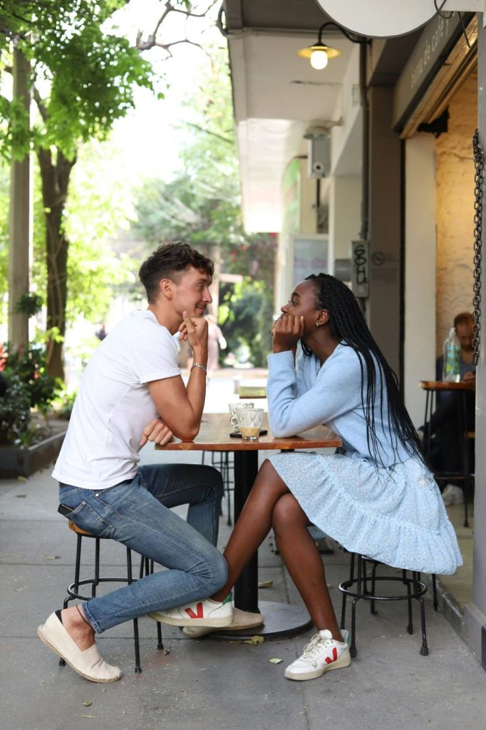 Couple smiling at each other at a street café table